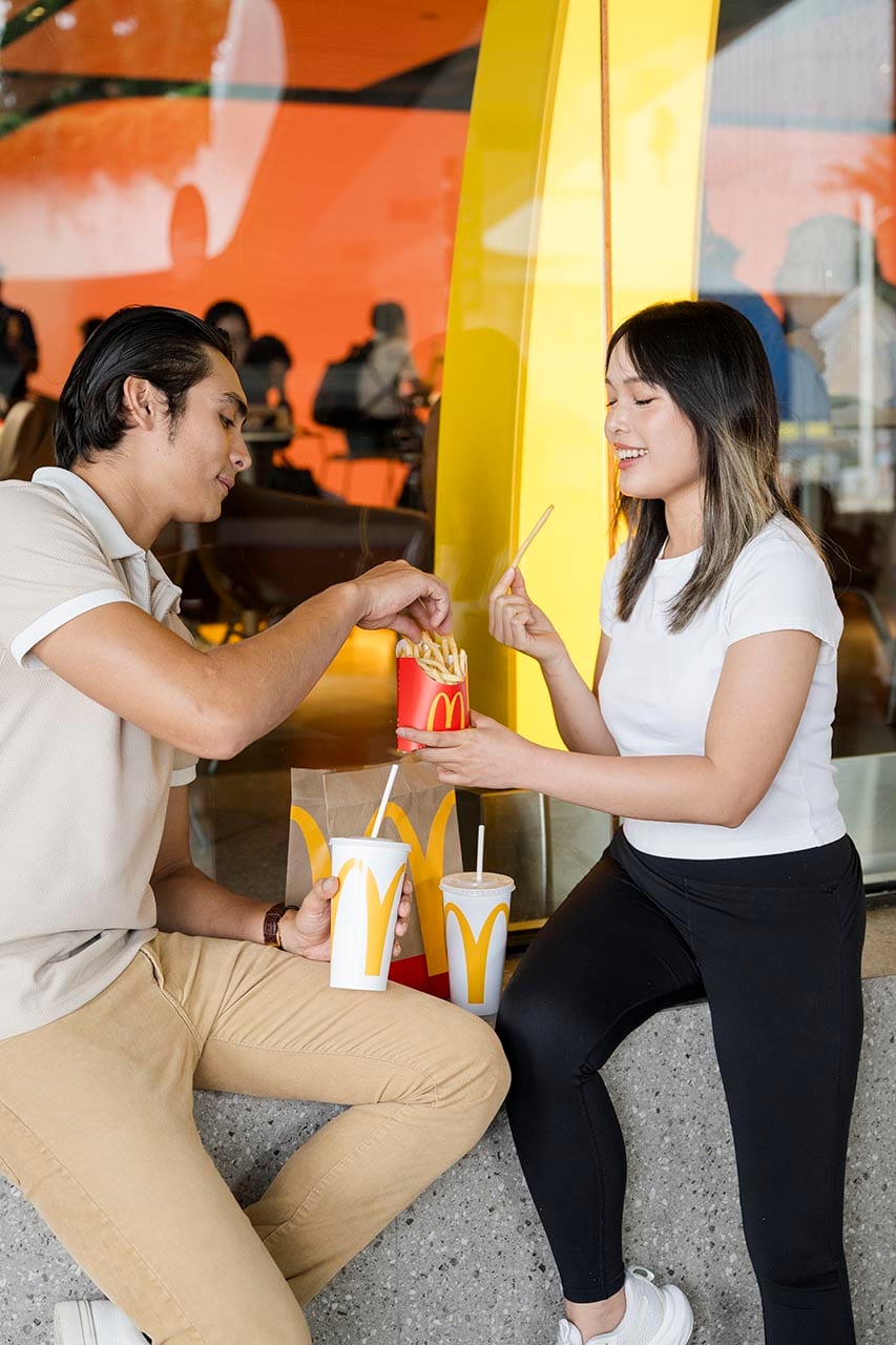 Amigos compartiendo patatas fritas en un restaurante McDonald's